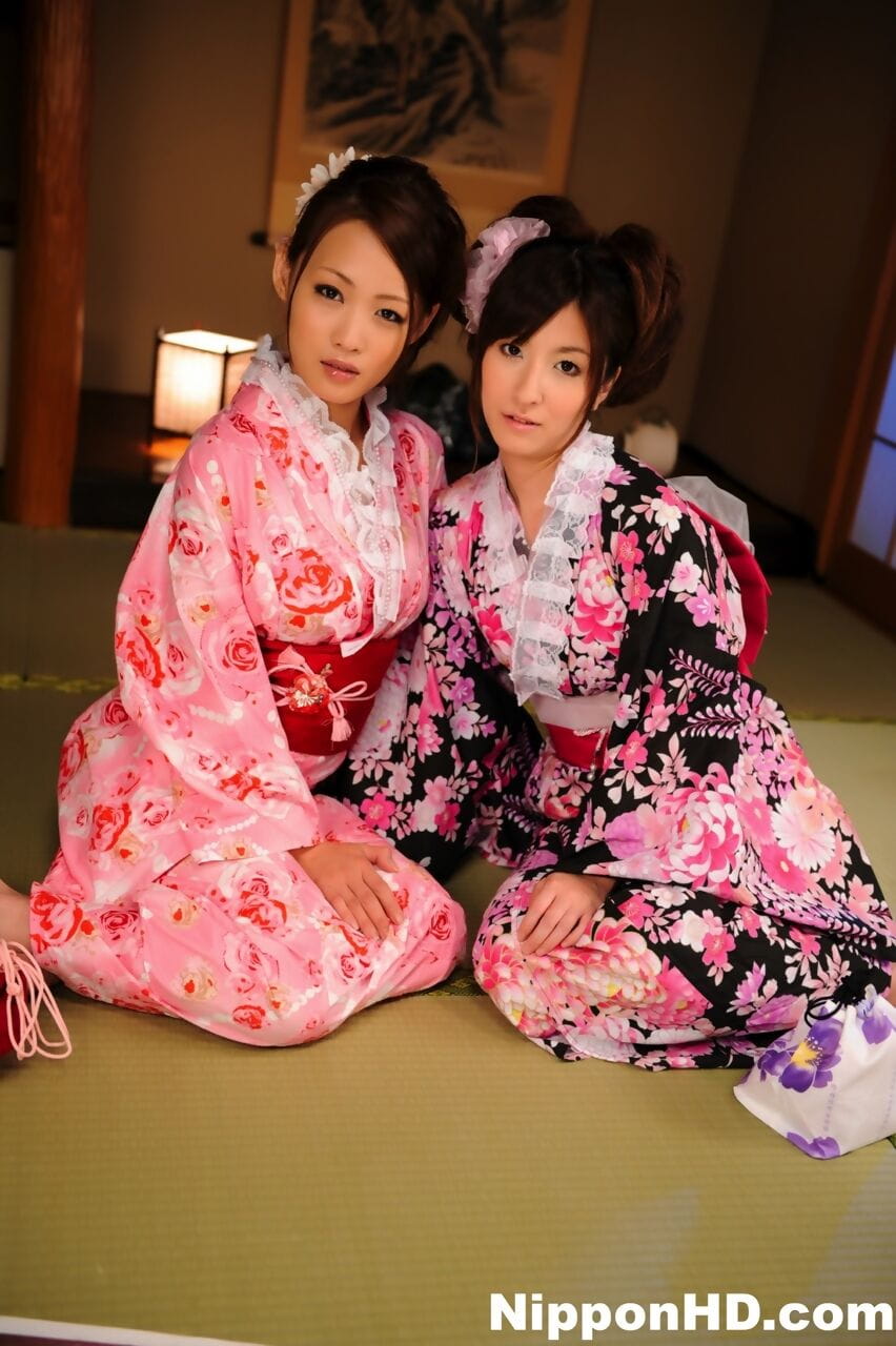 A pair of Japanese Geishas model together in their brightly colored kimonos page 1