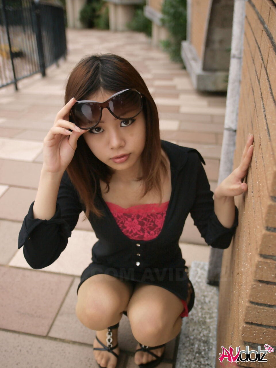 Fully clothed Japanese girl lifts up sunglasses to show her pretty face page 1