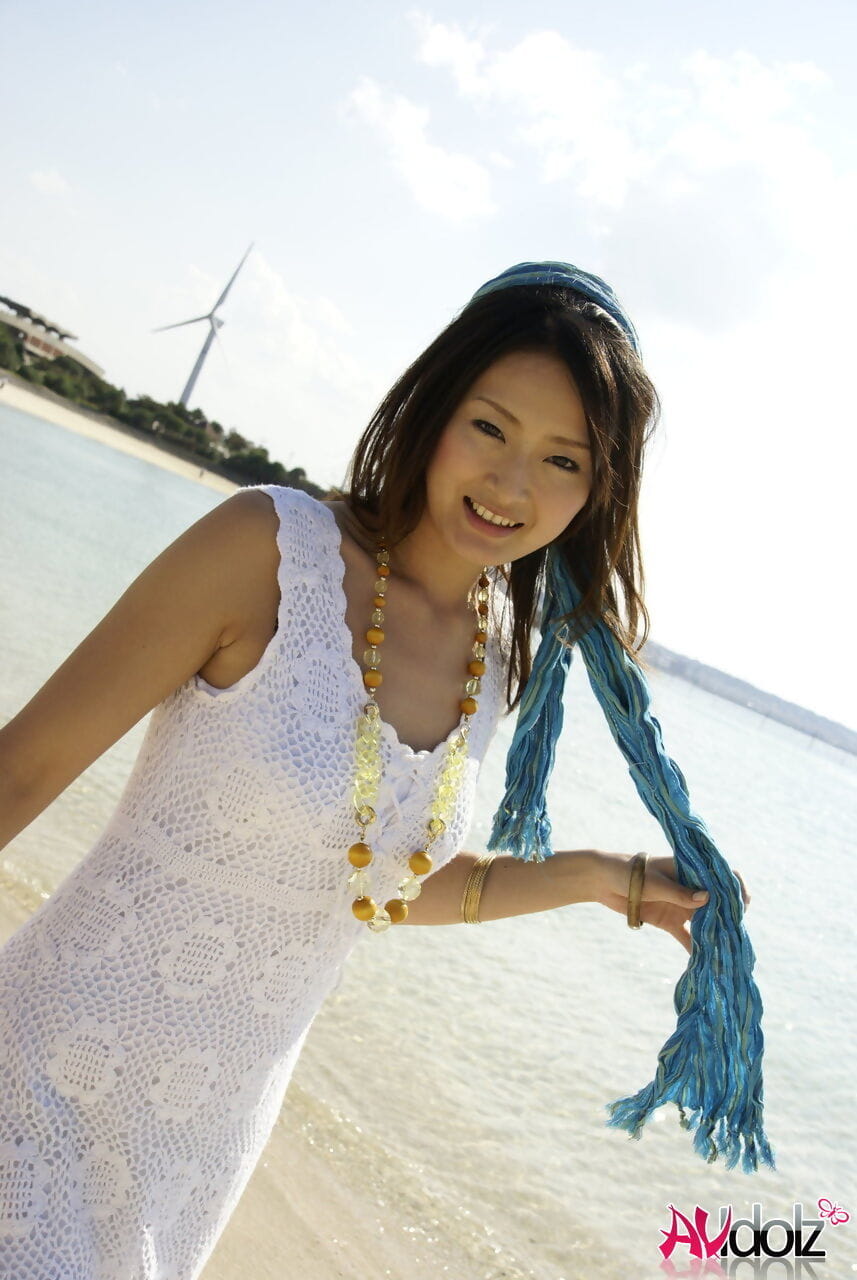 Asian girl wander into the ocean to her knees in a white dress page 1