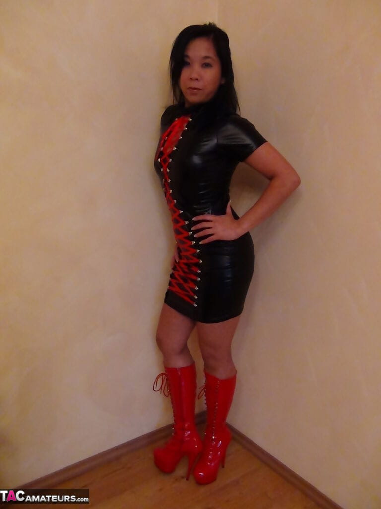 Beautiful Asian female in hot latex and high heel boots flashes sexy upskirt page 1