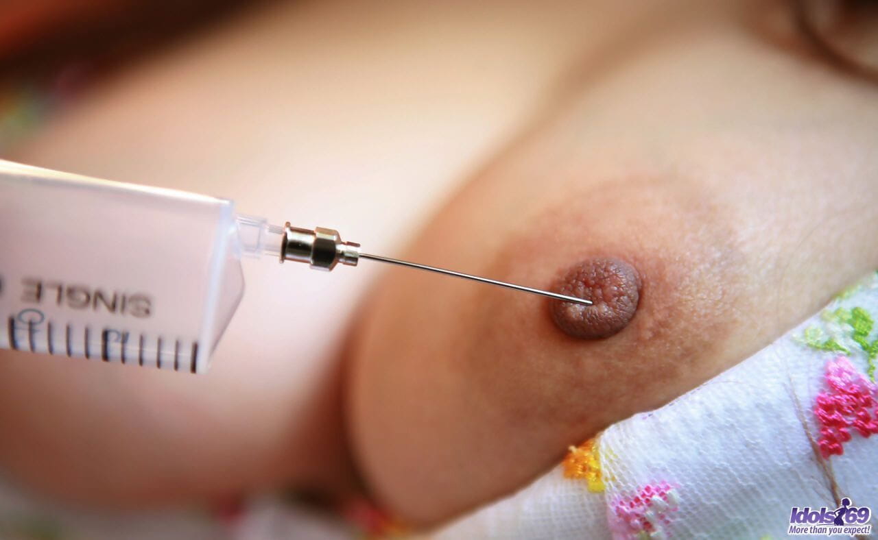 Kinky Japanese nurse Namie Koshino pokes her naked body parts with a needle page 1